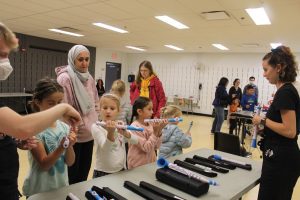 Kids and parents taking a look at beginner band instruments during a Bandology Community Event