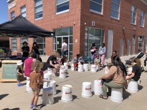 Children playing bucket drums as a group activity during a Bandology community music event