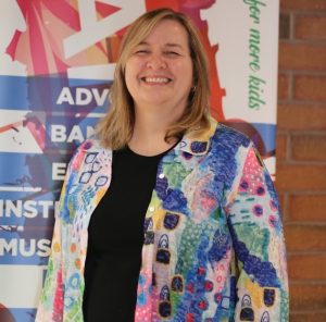 Tracey Durand giving a big smile in front of a Bandology banner sign